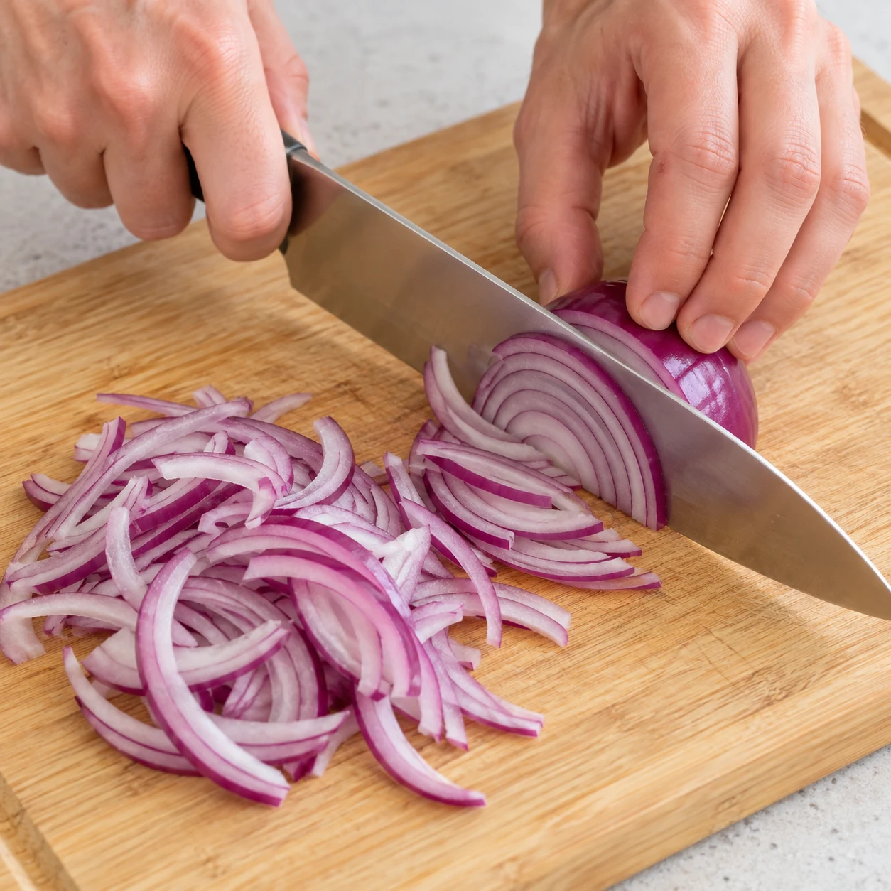 Émincez le demi-oignon rouge (60 g) en fines lamelles, comme celles versées dans la recette d’origine.