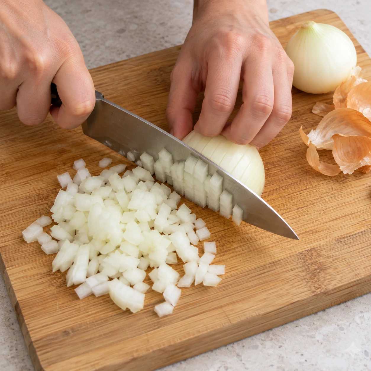 Découpe d’un oignon blanc en petits morceaux sur planche stable avec main en griffe ; état des morceaux sourcé par la capture, coupe par la recette d’origine.