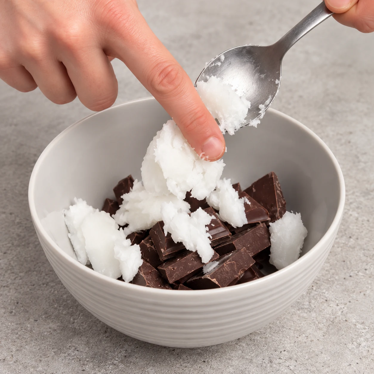 Ajoute les 30 g d’huile de coco au chocolat en morceaux. État à montrer : L’huile de coco est réunie avec les morceaux de chocolat.