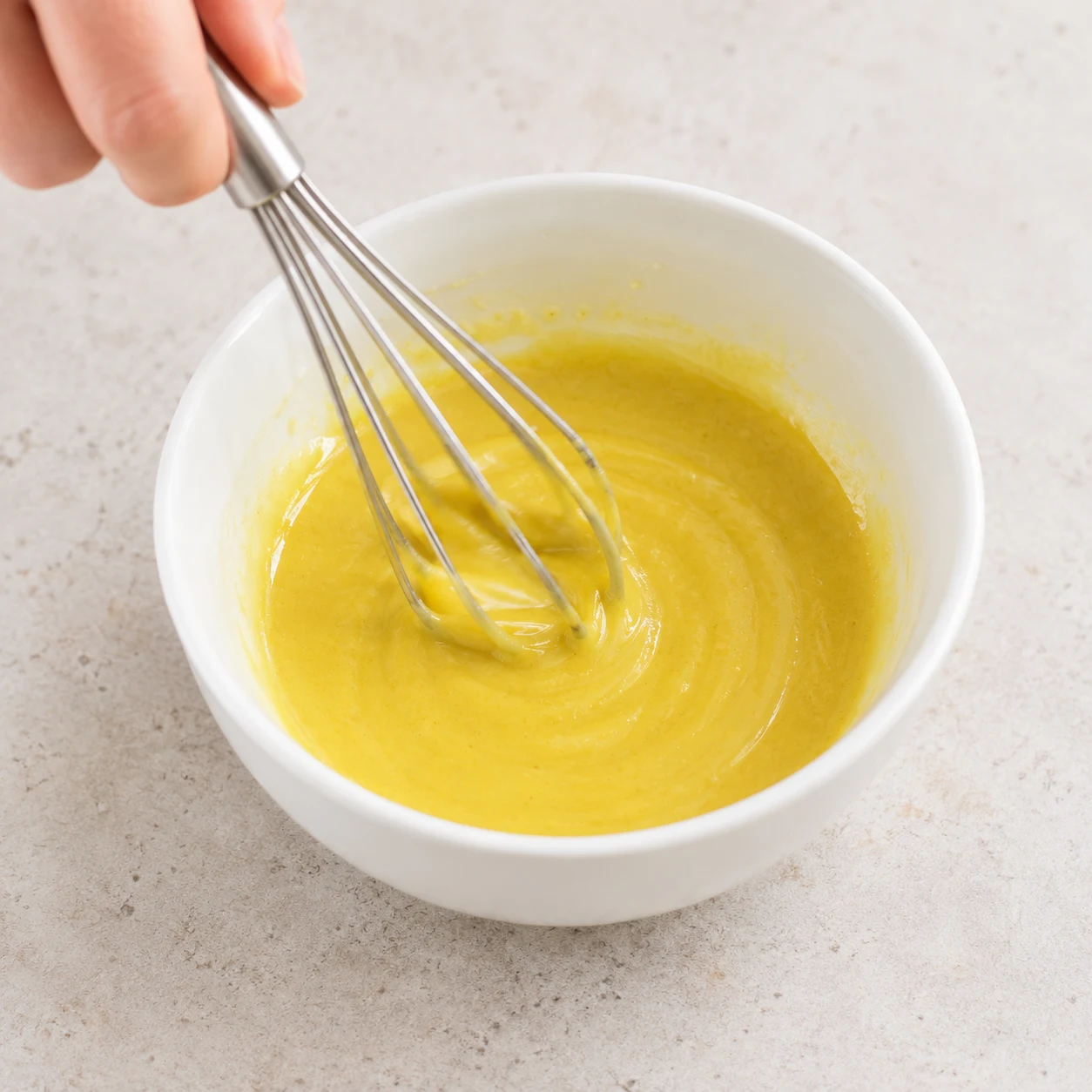 Fouetter la moutarde et l’huile : La sauce jaune est homogène, sans huile séparée en surface.