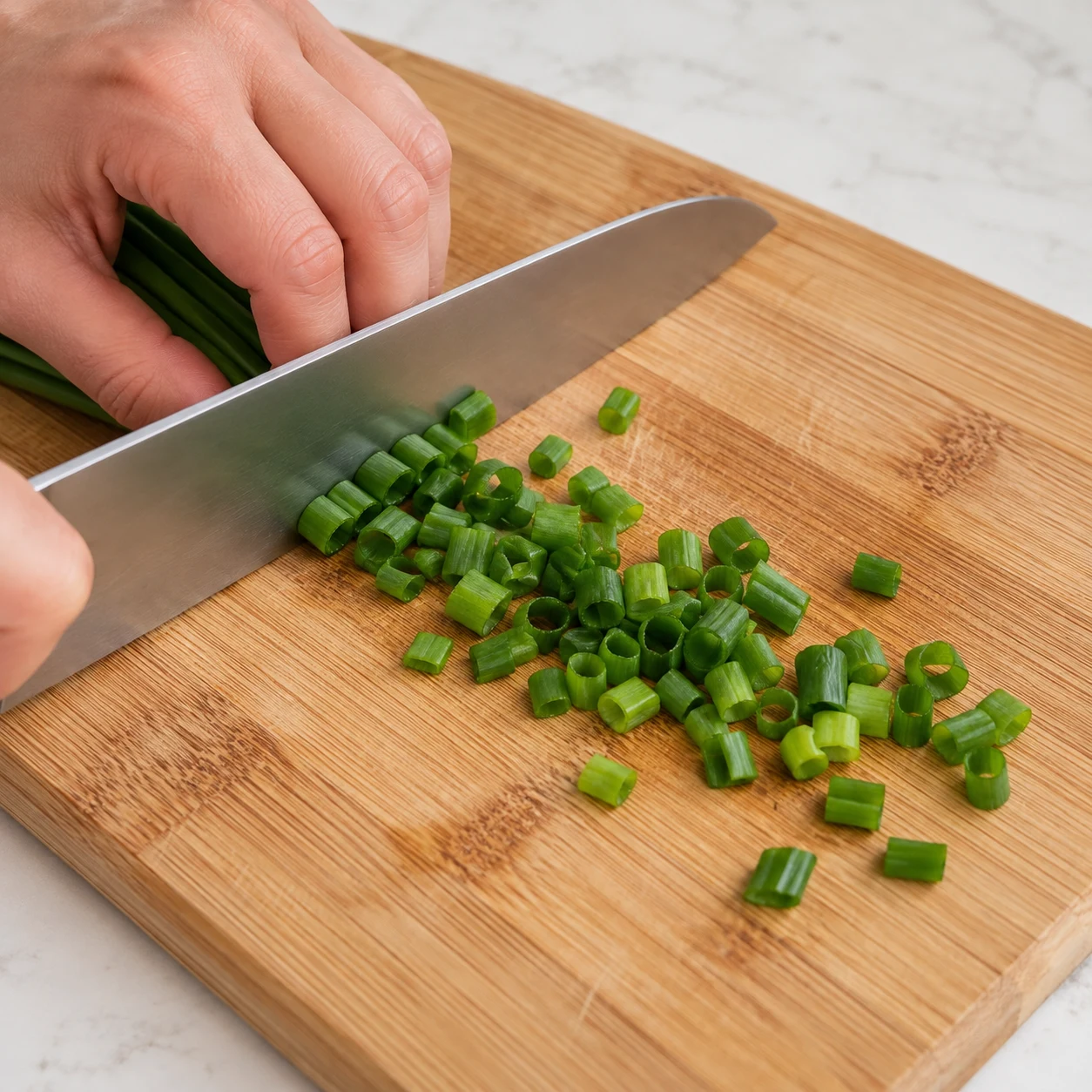Coupe quelques morceaux du vert d’oignon nouveau pour la garniture facultative. Une seule phase, sans texte ni personne identifiable. Pour la variante, montrer du tofu émietté et jamais des granulés secs, du doubanjiang ou des baies de Sichuan.